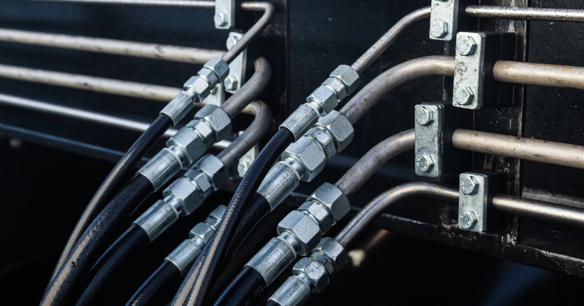 A hydraulic hose system is on display, showcasing eight different hoses. Each hose requires a different fitting due to size.