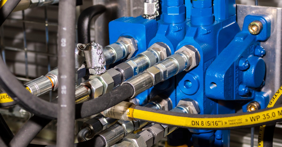 A close-up of hydraulic equipment. Many different hoses and valves are connected to the equipment.