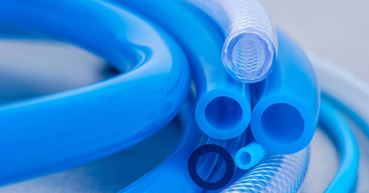 A close-up of various kinds of pneumatic tubing. Each tube is a different size and material and is either blue or clear.