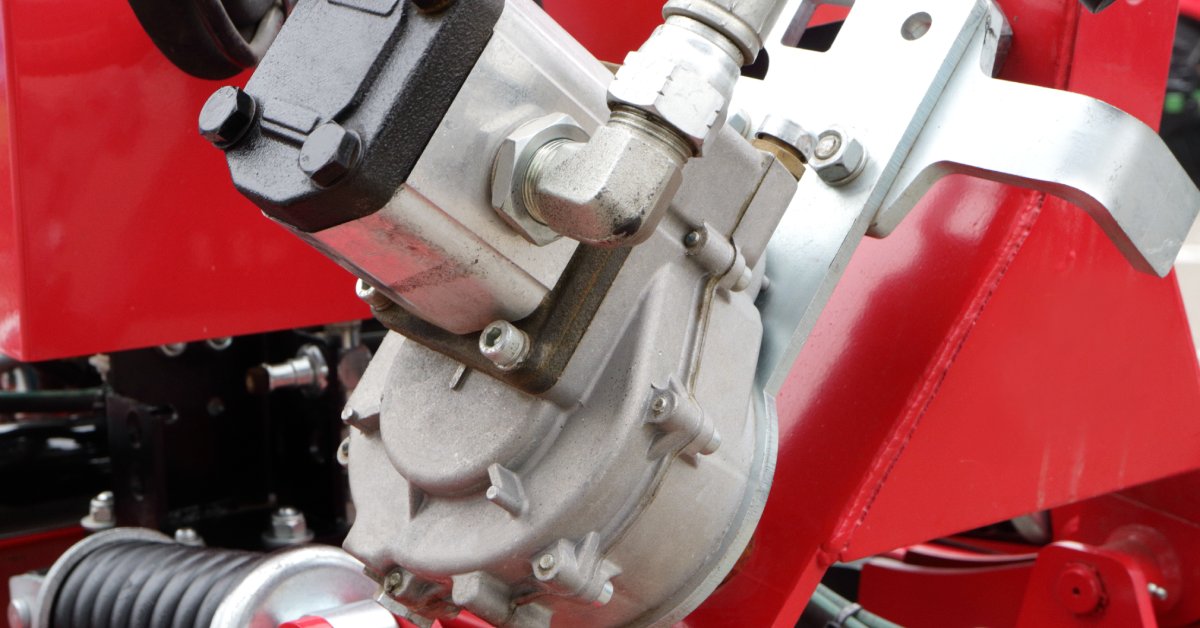 A hydraulic motor being used in some machinery. The equipment is painted red and the motor is being protected by metal.