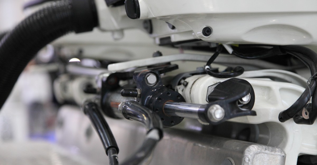 The hydraulic system components of a motorboat, consisting of a steering rod, cylinder, pipes, and a clamp.