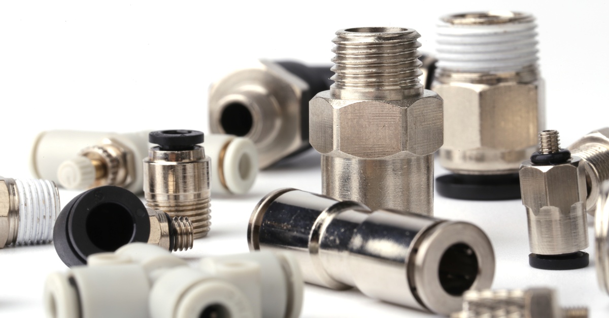 Several pneumatic fittings of different shapes and sizes placed together against a plain white background.